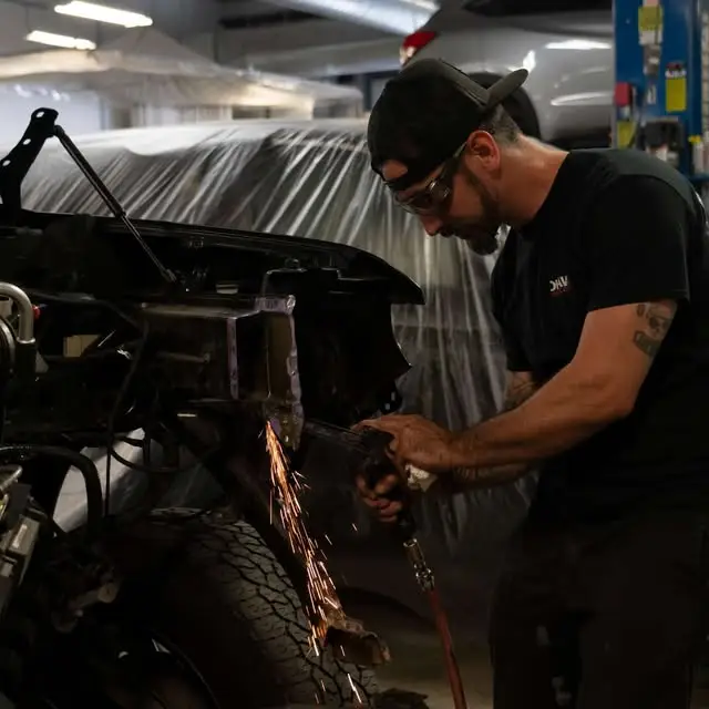 Man with Mohawk Collision Shirt using tool and protective equipment